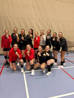 Speelsters van Divo Ingelmunster in clubkledij in de sporthal